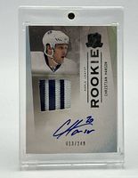 Front of the card inside plastic holder showing patch, autograph, serial number