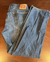 Jeans folded showing rear pocket, leather patch, red tab