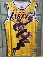 Front view of yellow Lakers Kobe Bryant Mitchell & Ness jersey showing graphic, team name and bottom patch