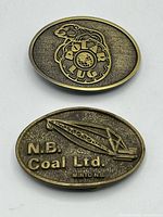 Both brass-tone belt buckles side by side, showing overall design and size comparison