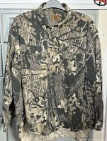 Front view of Duxbak Mossy Oak camouflage long sleeve shirt.