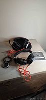 Both headsets with cables, USB controller, pouch and manual on tabletop