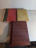 Three hardcover books stacked showing covers