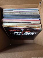 Box of stacked LP records, top jacket 'The First Man in Space Jose Jimenez The Astronaut'