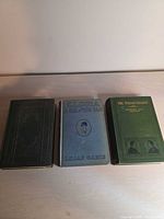 Front covers of the three antique hardcover books