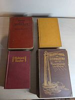 Four hardcover books laid flat showing front covers