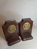 Front view of both wood bookends with brass medallions displayed upright