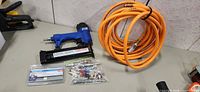 Overall lot showing nailer, air hose, nails pack, accessory bag