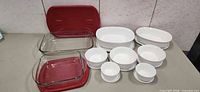 All items laid out showing glass dishes with lids and white CorningWare pieces