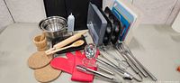 Full lot overview showing bakeware, utensils, bowls, cutting boards and accessories
