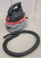Front view of Husky wet/dry vacuum with hose attached