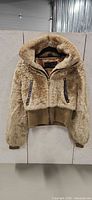 Front view of beige faux fur bomber jacket on hanger
