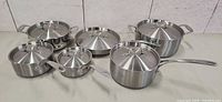 Full set of six stainless steel pots and saucepans with lids