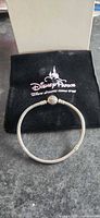 Full view of bracelet laid flat with Disney Parks pouch