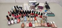 Full lot overview showing drill, lamp box, polishes, powders, tips, foot rasp