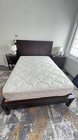 Full view of assembled wood double bed frame with mattress