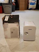 Fridge with original box side by side on floor