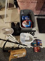 Overview of all items: weighted vest, fan, pull-up bar pieces, Conair foot bath, Brita pitcher, Bissell Steam Shot, Friends DVD sets in tote