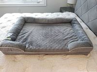 Top view of entire grey bolstered dog bed on mattress