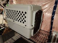 Side view of grey plastic pet crate showing ventilation holes