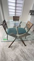 Full view of glass top dining table with wood X base