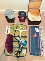 Full group shot showing hair dryer, blanket, storage box, and three caps