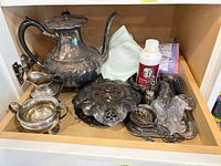 Teapot, creamer, sugar bowl, pierced dish, trays and cleaning polish visible