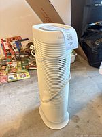 Full view of the white Honeywell tower air purifier standing upright with cord