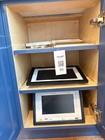 Both digital photo frames on cabinet shelves showing fronts and overall condition