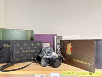 Camera and multiple photo albums on shelf