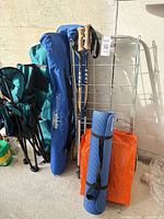 Group view of chairs, umbrella sleeve, trekking poles, yoga mat and tote