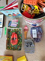 Overview showing all items including Tinkertoy bucket, marbles, book, chalk, hat, pouch and comb