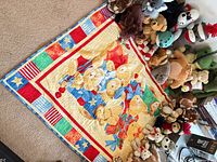 Overview of patchwork crib quilt and large group of plush animals
