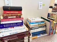 Stack of reference and non-fiction books plus additional stack including Eats, Shoots & Leaves