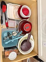 Drawer view with utensils, bowls, salad spinner and accessories