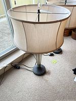 Pair of table lamps showing one lamp with beige shade and clear acrylic base