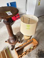 Pedestal table, lamp with shade, wooden wine rack grouped on floor