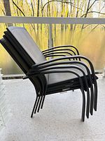 Four stackable patio chairs side view showing frame and sling