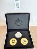Open display case showing three coins in foam insert