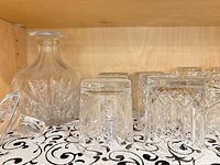 Shelf with decanter, stopper, multiple tumblers