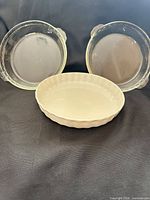 Front view showing two clear glass pie plates and one white stoneware tart dish