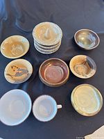 All 10 ceramic pieces arranged on black cloth