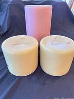 Front view of three pillar candles showing colors and size