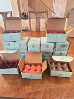 Front view showing stacked PartyLite boxes and open boxes displaying candles of various colors