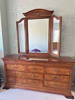 Front view of dresser showing nine drawers and tri-fold mirror