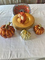 Group shot showing all items: gold chargers, patterned plate, fox figurine, three metallic pumpkins