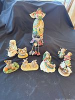 Group shot of all nine resin figurines arranged on black cloth