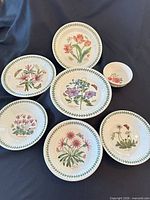 Overview of seven pieces showing floral plates and bowls