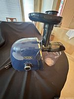 Left side view of Fezen juicer showing brand label, feed chute, and pulp cup