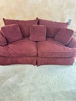 Front view of maroon sofa with pillows